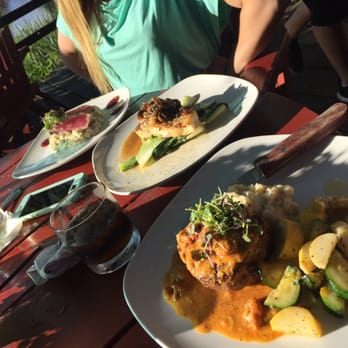 River Deck - a woman sitting at a table with plates of food - American Near Me - Hayward, Wisconsin