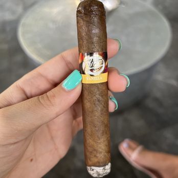Galiano Cigar Room - a hand holding a cigar - Cigar Bars Near Me - Coral Gables, Florida