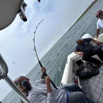 On the Edge Charters - Reeling in a oversized striped bass released to live another day - Fishing Near Me
