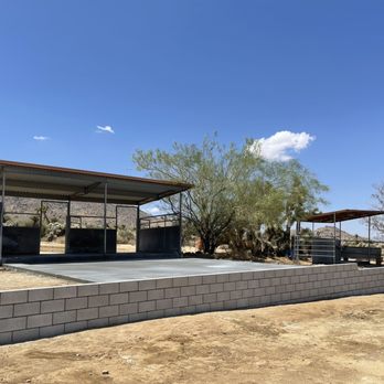 Breez Construction - a concrete block retaining wall with a pergol roof - General Contractors Near Me