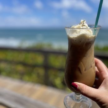 The Dune Deck Cafe - a hand holding a glass of iced coffee - Breakfast & Brunch Near Me - Lantana, Florida The Dune Deck Cafe - a hand holding a glass of iced coffee - Breakfast & Brunch Near Me - Lantana, Florida