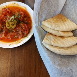 Stewed tomatoes with olives and fresh pita bread