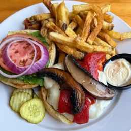 Burger with peppers and mushrooms with a side of mayo and fries Burger with peppers and mushrooms with a side of mayo and fries