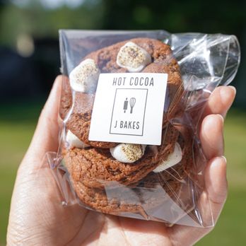 J Bakes - a hand holding a bag of hot cocoa cookies - Desserts Near Me J Bakes - a hand holding a bag of hot cocoa cookies - Desserts Near Me