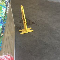 Wet floor sign, when clearly it's wet, but a mop could easily fix the problem... Wet floor sign, when clearly it's wet, but a mop could easily fix the problem...
