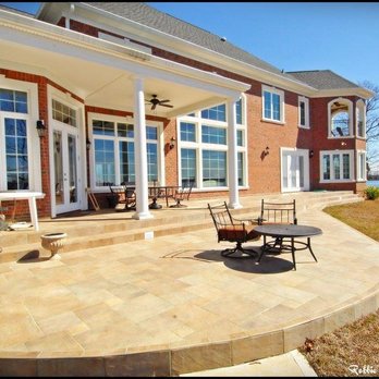 Dunbar Builders - a patio with a table and chairs - General Contractors Near Me