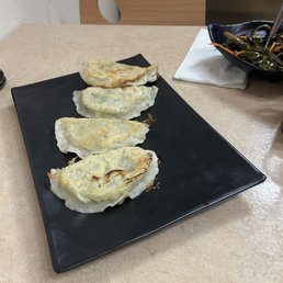 three dumplings on a black plate three dumplings on a black plate