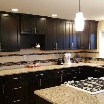 Renovation Resolutions - a kitchen with black cabinets and a white stovetop - General Contractors Near Me - Sumner, Washington Renovation Resolutions - a kitchen with black cabinets and a white stovetop - General Contractors Near Me - Sumner, Washington