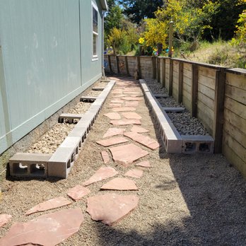 Riverfront Lawn Basics - a stone path between two houses - Home Cleaning Near Me - Florence, Oregon