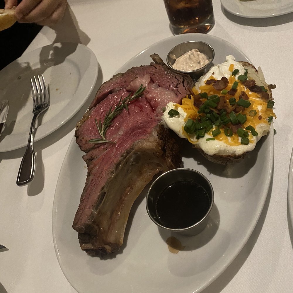 Steve Fields - Medium rare 20oz bone in prime rib with loaded baked potato - Steakhouses Near Me - Plano, Texas Steve Fields - Medium rare 20oz bone in prime rib with loaded baked potato - Steakhouses Near Me - Plano, Texas