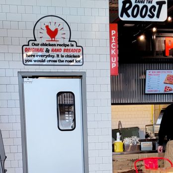 Raise the Roost - a man standing in a restaurant - Chicken Wings Near Me - Manassas, Virginia