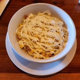 Breakfast bowl with ham, eggs, beans, cheese, and sour cream.