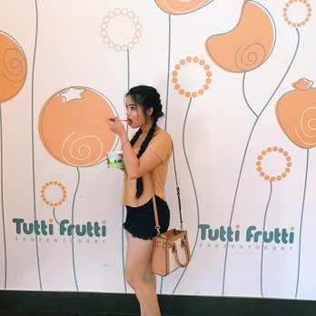 Tutti Frutti At La Quinta - a woman standing in front of a tutti frutti mural - Ice Cream & Frozen Yogurt Near Me - La Quinta, California Tutti Frutti At La Quinta - a woman standing in front of a tutti frutti mural - Ice Cream & Frozen Yogurt Near Me - La Quinta, California