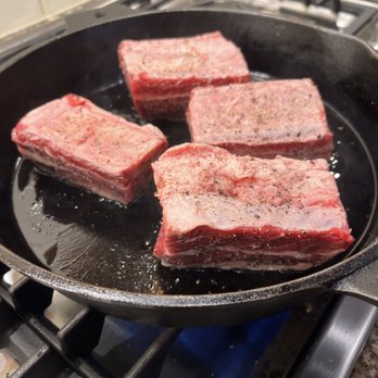 Sweet Tree Farm - four pieces of meat cooking in a skillet - Meat Shops Near Me - Carlisle, New York Sweet Tree Farm - four pieces of meat cooking in a skillet - Meat Shops Near Me - Carlisle, New York