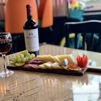Attika - a plate of cheese, meat, grapes, and a glass of wine - Latin American Near Me - Lawrence, Massachusetts