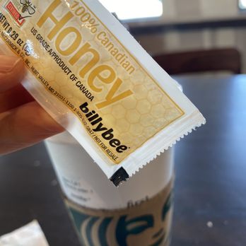 Starbucks - a hand holding a coffee cup and a packet of honey - Coffee & Tea Near Me - Bronx, New York Starbucks - a hand holding a coffee cup and a packet of honey - Coffee & Tea Near Me - Bronx, New York