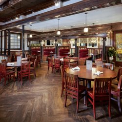 Dons Seafood - Covington - The main dining room at our Covington location, featuring cozy red booth seating, reclaimed wood accents, and a warm, industr...