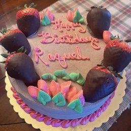 a birthday cake with chocolate covered strawberries