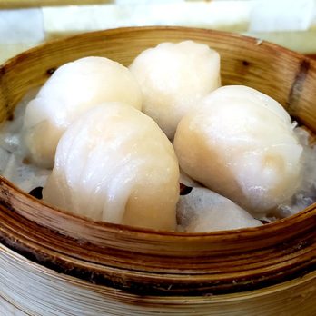 Dim Sum King - Six steamed dumplings are arranged in a bamboo steamer basket, with a soft, translucent appearance, placed on a wooden surface. - Dim Sum Near Me - Toronto, Ontario