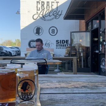 Mississippi Ale House - a man sitting at a picnic table with two beers - Beer Bar Near Me - Olive Branch, Mississippi Mississippi Ale House - a man sitting at a picnic table with two beers - Beer Bar Near Me - Olive Branch, Mississippi