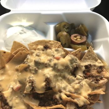 Fastacos - a tray of nachos with cheese and pickles - Mexican Near Me - Woodstock, Illinois Fastacos - a tray of nachos with cheese and pickles - Mexican Near Me - Woodstock, Illinois