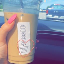 a hand holding a cup of coffee a hand holding a cup of coffee