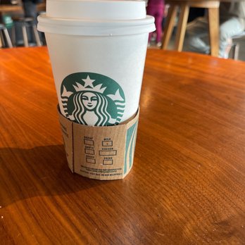 Starbucks - a starbucks cup sitting on a table - Coffee & Tea Near Me - Cupertino, California Starbucks - a starbucks cup sitting on a table - Coffee & Tea Near Me - Cupertino, California