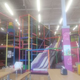 Children's indoor play area featuring multicolored climbing frames, slides, and soft play equipment at Kids Empire Paramus.