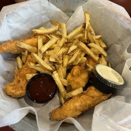 Chicken fingers with fresh cut fries and a side of sweet BBQ sauce.