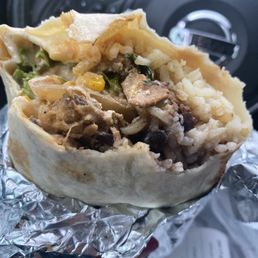 flour tortilla with chicken, black beans white rice and lettuce, queso fresco, grilled onions, corn, sour cream, and their chipotle sauce