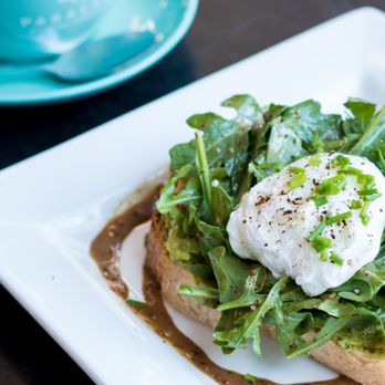 Prado Cafe - The Prado Toast - Toast with avocado pea spread, fresh arugula topped with a medium poached egg, salt pepper and mustard balsamic - Cafes Near Me - Vancouver, British Columbia Prado Cafe - The Prado Toast - Toast with avocado pea spread, fresh arugula topped with a medium poached egg, salt pepper and mustard balsamic - Cafes Near Me - Vancouver, British Columbia