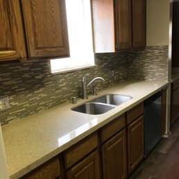 Beautiful, stainless steel sink and faucet, backsplash and cabinets refinished