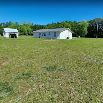 At The Cornerstone - a view of a field with two houses in the background - Lawn Services Near Me At The Cornerstone - a view of a field with two houses in the background - Lawn Services Near Me