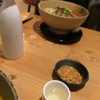 Kippo Ramen - Carafe of Hot Sake, fried garlic side, and my friend's spicy tonkotsu in the background - Ramen Near Me - Baltimore, Maryland
