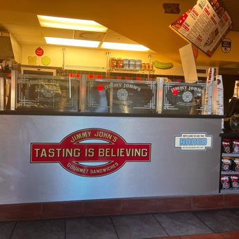 Jimmy John's - a restaurant counter with a sign that says tasting is believing - Sandwiches Near Me - Chicago, Illinois Jimmy John's - a restaurant counter with a sign that says tasting is believing - Sandwiches Near Me - Chicago, Illinois
