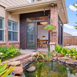 Gill Construction - Four-Season Patio: Koi pond and garden beds welcome you at the patio entrance, steps from the sliding glass doors.