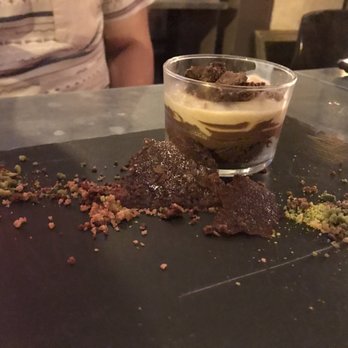La Bulle - Chocolate layer dessert (diff levels of darkness). Crusted orange chocolate with sprinkles of pistachio bits around the cup - French Near Me - Paris, 75 La Bulle - Chocolate layer dessert (diff levels of darkness). Crusted orange chocolate with sprinkles of pistachio bits around the cup - French Near Me - Paris, 75
