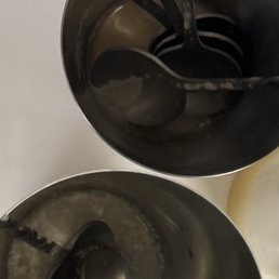 Disgusting cups with spoons they are using to stir everyone's drinks