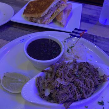 Smugglers Cocina Cubana - Vaca Frita and Cuban Sandwich across the table - Cuban Near Me - Miami, Florida Smugglers Cocina Cubana - Vaca Frita and Cuban Sandwich across the table - Cuban Near Me - Miami, Florida