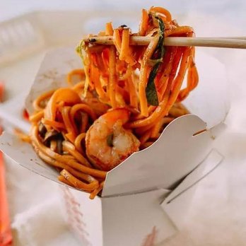 First Wok - a fork lifting noodles from a takeout box - Chinese Near Me - Merrillville, Indiana