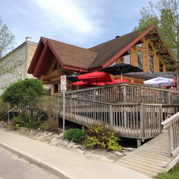 Le Zouk - a restaurant with a wooden deck and red umbrellas - Pizza Near Me - Montebello, Quebec Le Zouk - a restaurant with a wooden deck and red umbrellas - Pizza Near Me - Montebello, Quebec