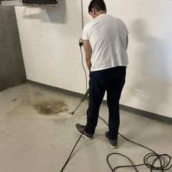 Sparkle Cleaning - We do pressure washing! Here, our employee is pressure washing a garbage room in a condo/commercial space.