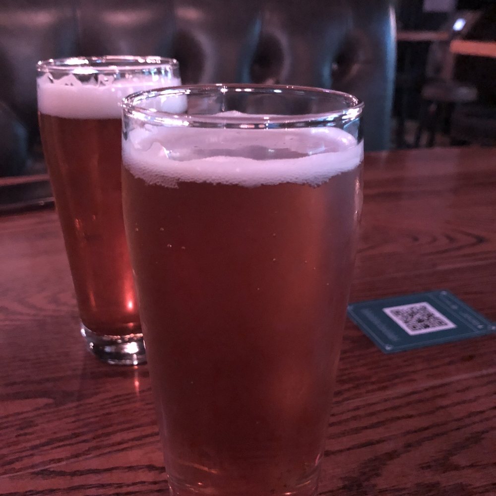Library Square - two glasses of beer on a table - Pubs Near Me - Vancouver, British Columbia Library Square - two glasses of beer on a table - Pubs Near Me - Vancouver, British Columbia