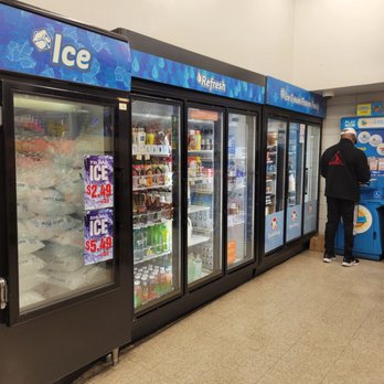 Quik Stop - a man standing in front of a refridgerator - Convenience Stores Near Me - San Leandro, California