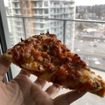 Pizza Factory - a hand holding a slice of pizza - Pizza Near Me - Coquitlam, British Columbia Pizza Factory - a hand holding a slice of pizza - Pizza Near Me - Coquitlam, British Columbia