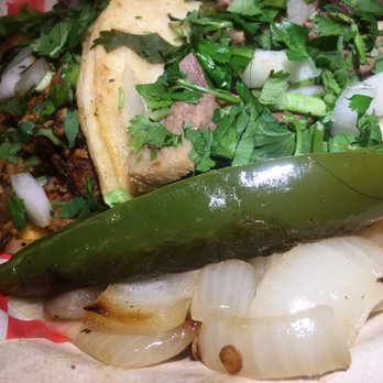 Taqueria La Bamba - a close up of a taco with onions and a pickle - Mexican Near Me - Monroe, Washington Taqueria La Bamba - a close up of a taco with onions and a pickle - Mexican Near Me - Monroe, Washington