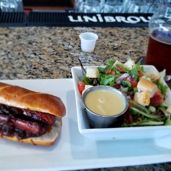 Castaways Gastropub - Cajun sausage in a pretzel bun and garden salad - Gastropubs Near Me - Jensen Beach, Florida Castaways Gastropub - Cajun sausage in a pretzel bun and garden salad - Gastropubs Near Me - Jensen Beach, Florida