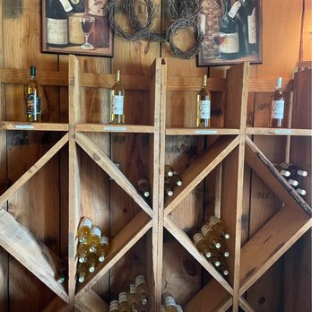 Zepeda Vineyard & Winery - a wine rack with bottles of wine - Wine Tasting Room Near Me - Pittsburg, Texas Zepeda Vineyard & Winery - a wine rack with bottles of wine - Wine Tasting Room Near Me - Pittsburg, Texas