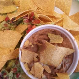 Poorly presented chips with what they call guacamole and crappy beans Poorly presented chips with what they call guacamole and crappy beans