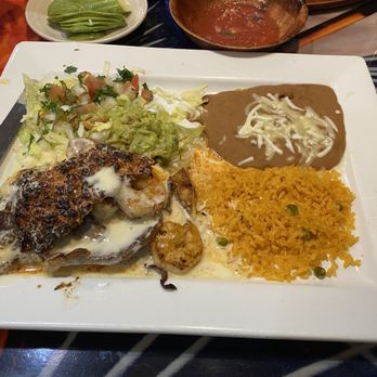 Blue TeQuila - El Matador - A plate of Mexican food includes grilled chicken with melted cheese, yellow rice, refried beans with cheese, and a side salad with guacamole and lettuce. - Mexican Near Me - Sergeant Bluff, Iowa